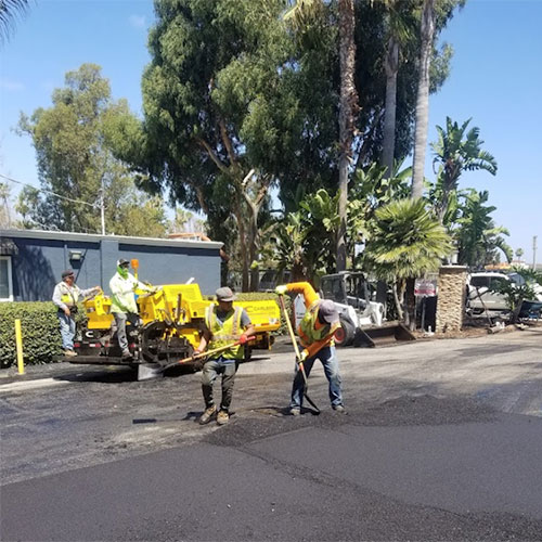 workers shoveling asphalt